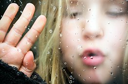 Wasser Mädchen hinter Fenster, an dem Tropfen rinnen