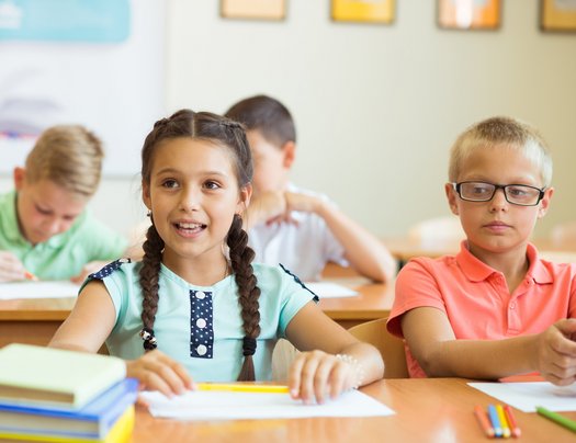 Schülerin und Schüler an ihren Sitzplätzen 