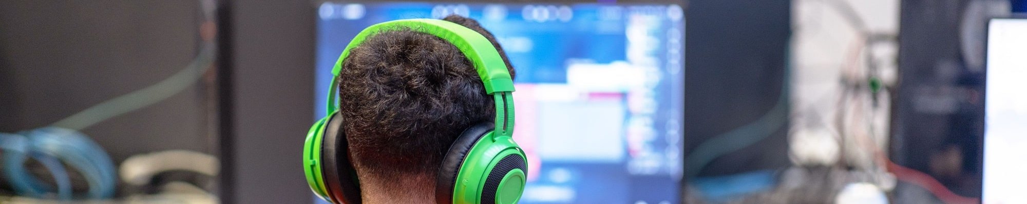 Junge sitzt mit Kopfhörern im Computerraum der Schule