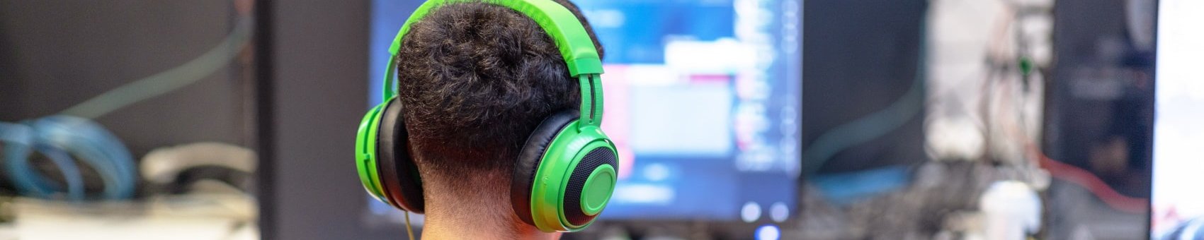 Junge sitzt mit Kopfhörern im Computerraum der Schule