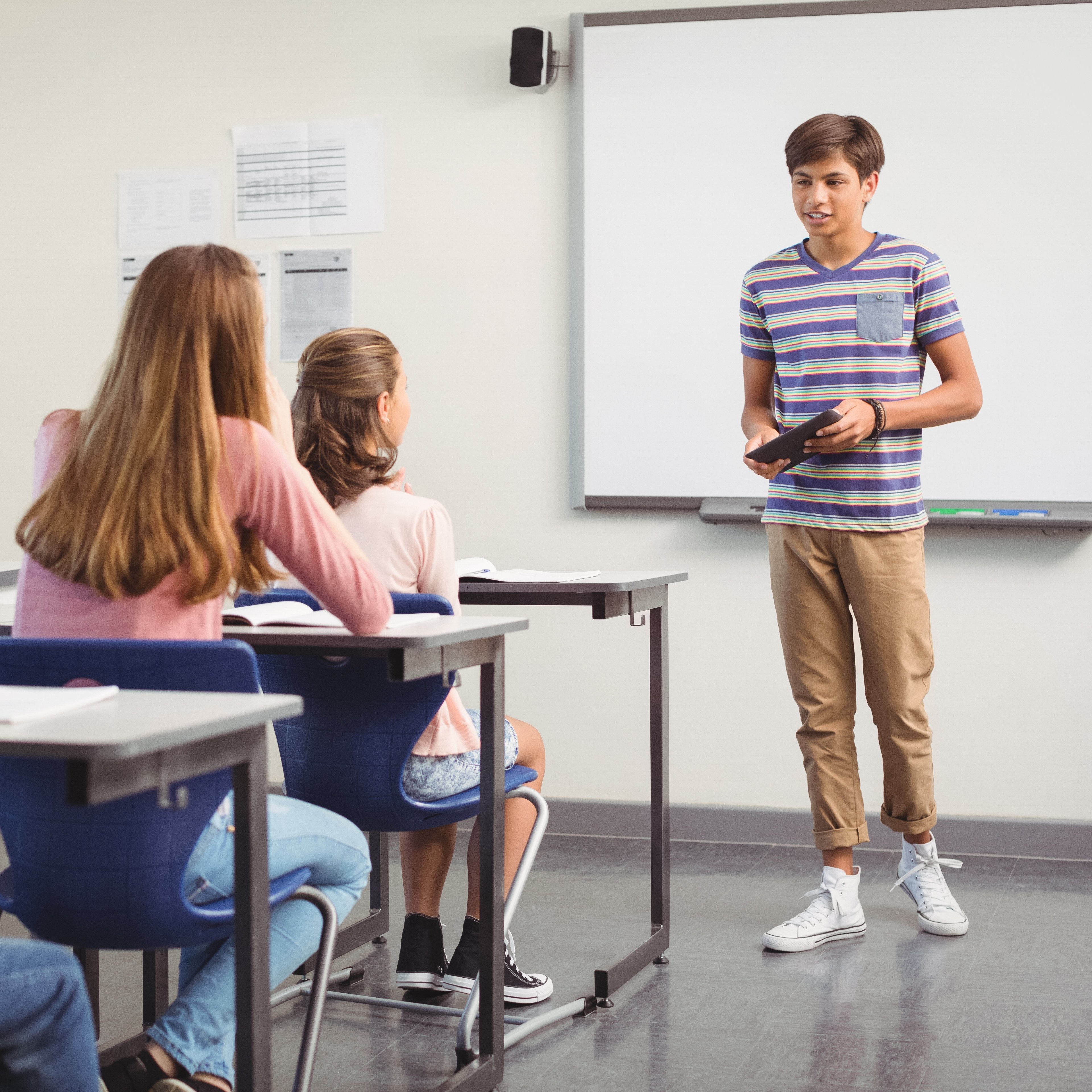 Junge präsentiert vor Klasse und übt Präsentationstechniken