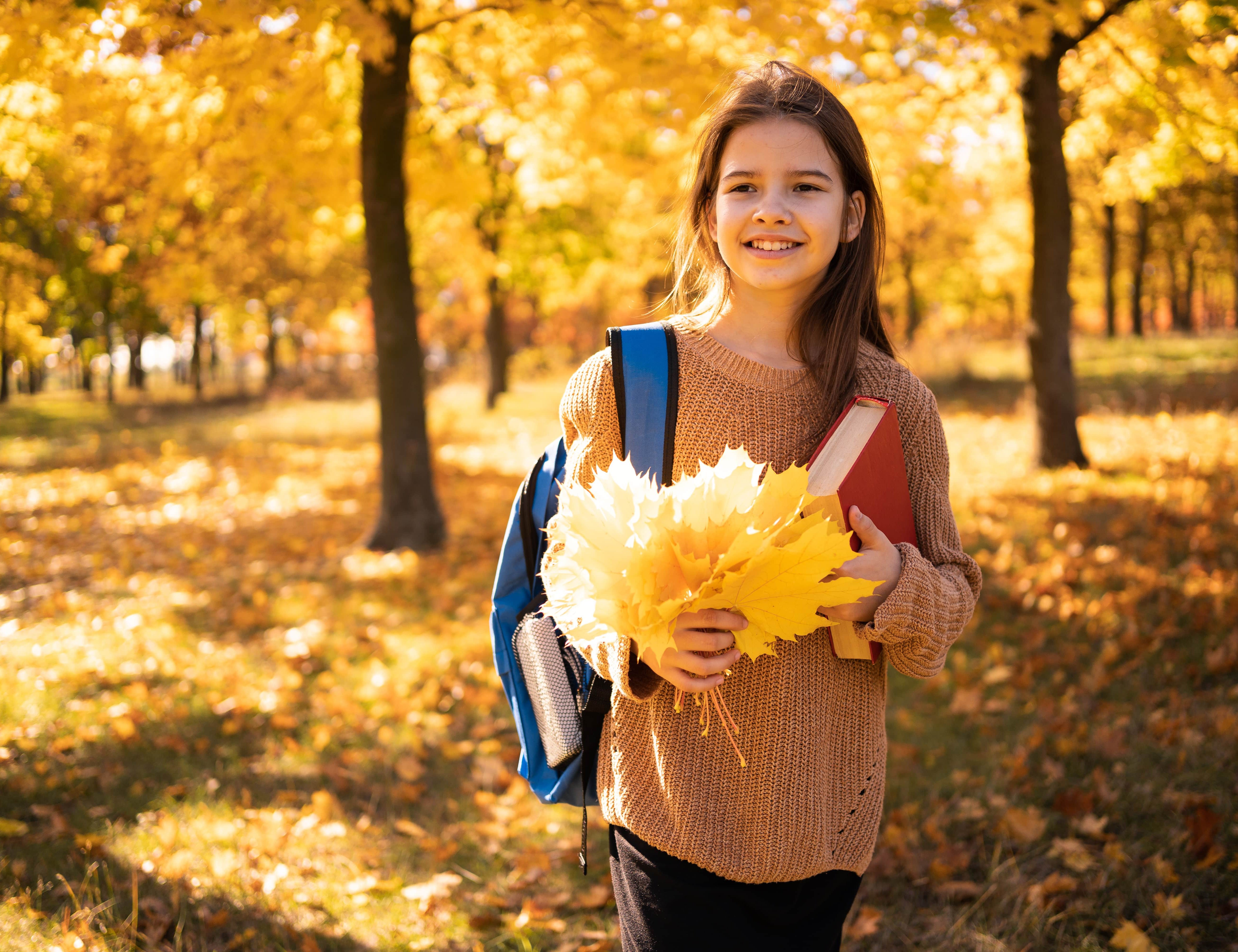 Schülerin im bunten Herbstlaub