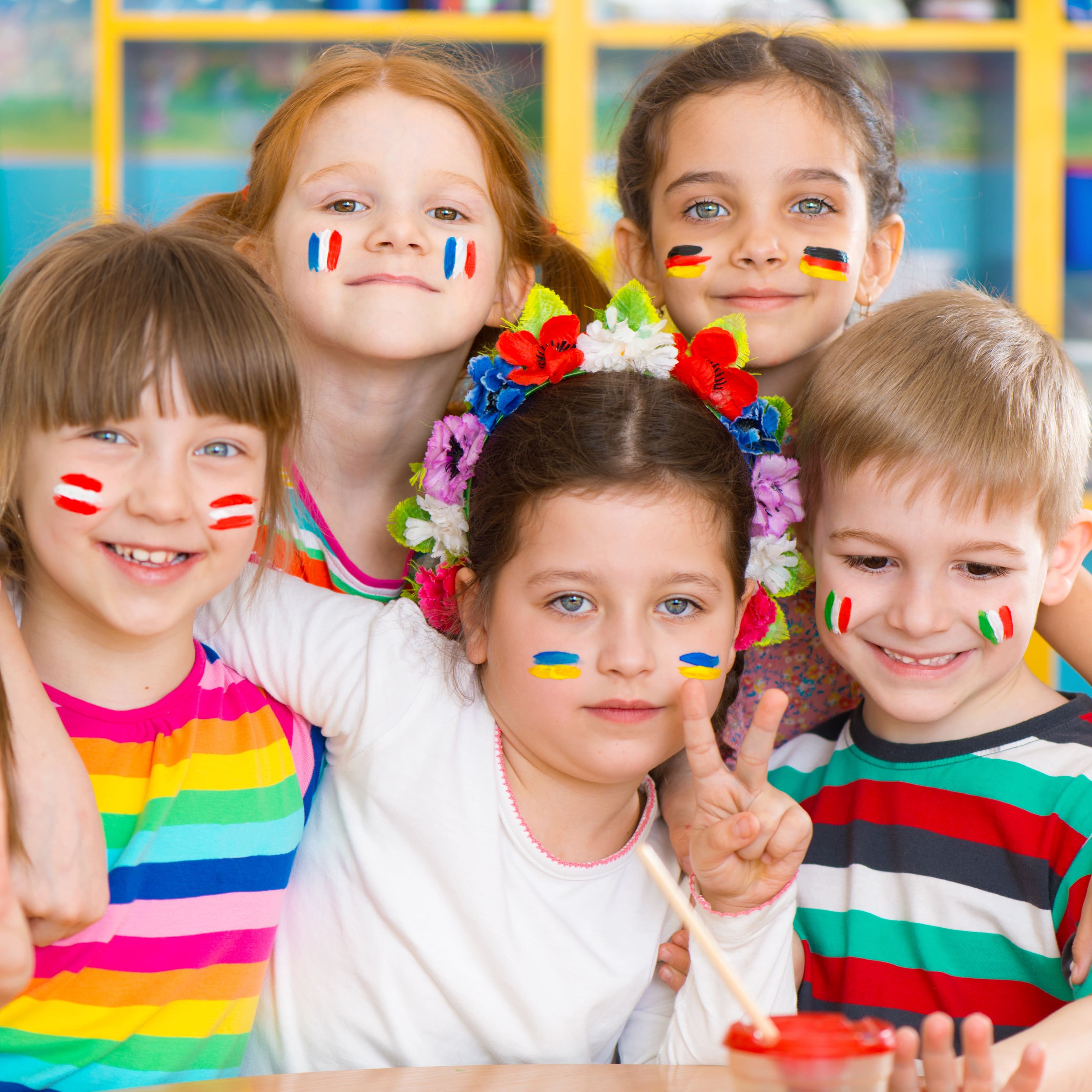 Schülerinnnen und Schüler mit verschiedenen Flaggen im Gesicht