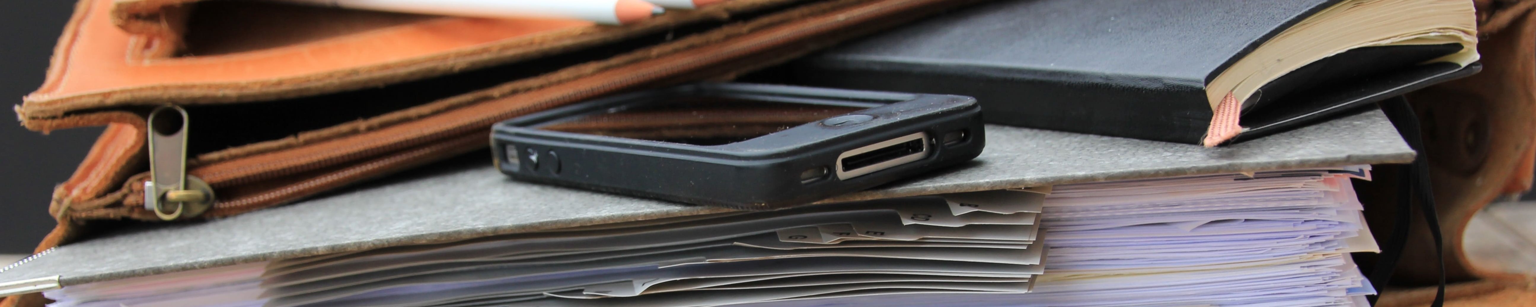 Lehrertasche mit Büchern und Smartphone