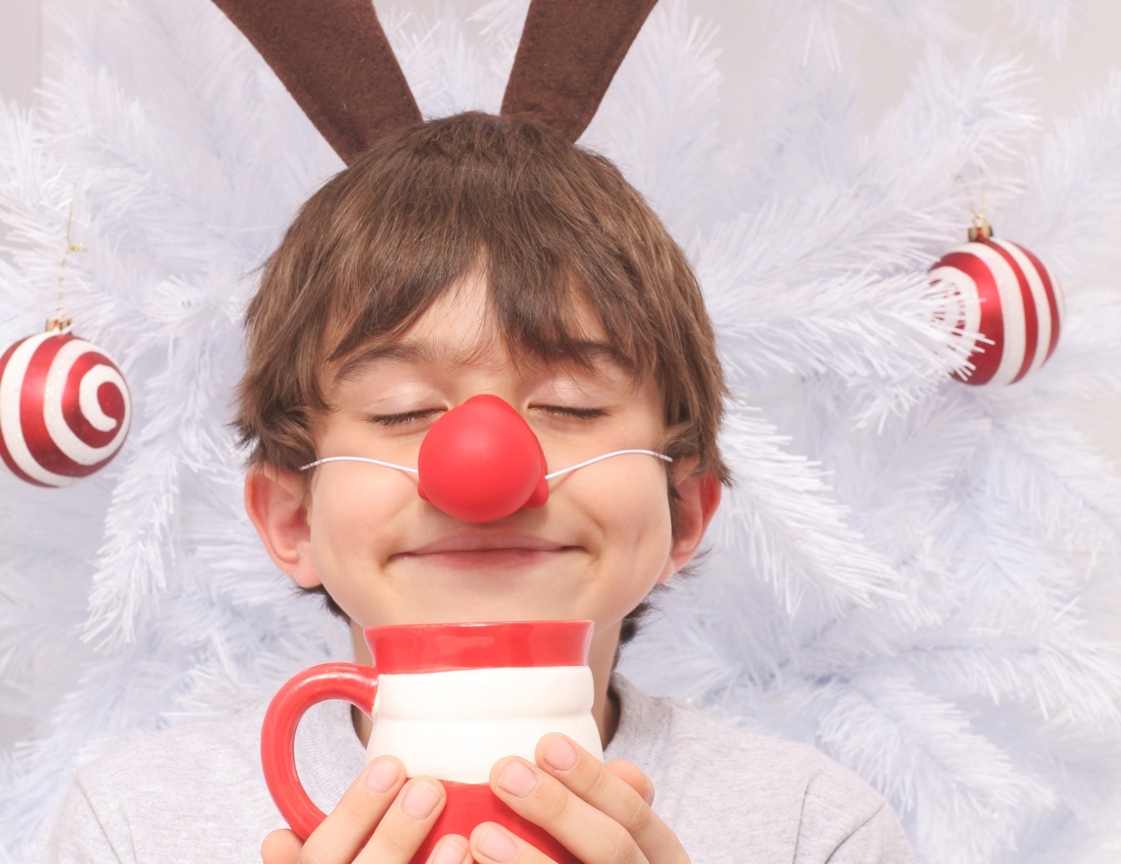 Kleiner Junge mit einer Tasse Kakao als Wichtel verkleidet