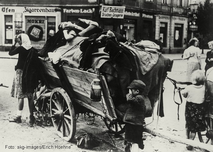 Familie auf der Flucht mit Holzwagen