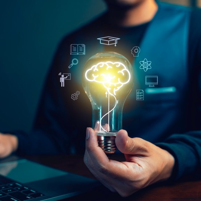 Mann vor Laptop hält eine leuchtende Glühlampe