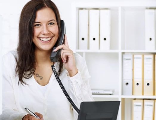 Auszubildende telefoniert freundlich und respektvoll am Telefon