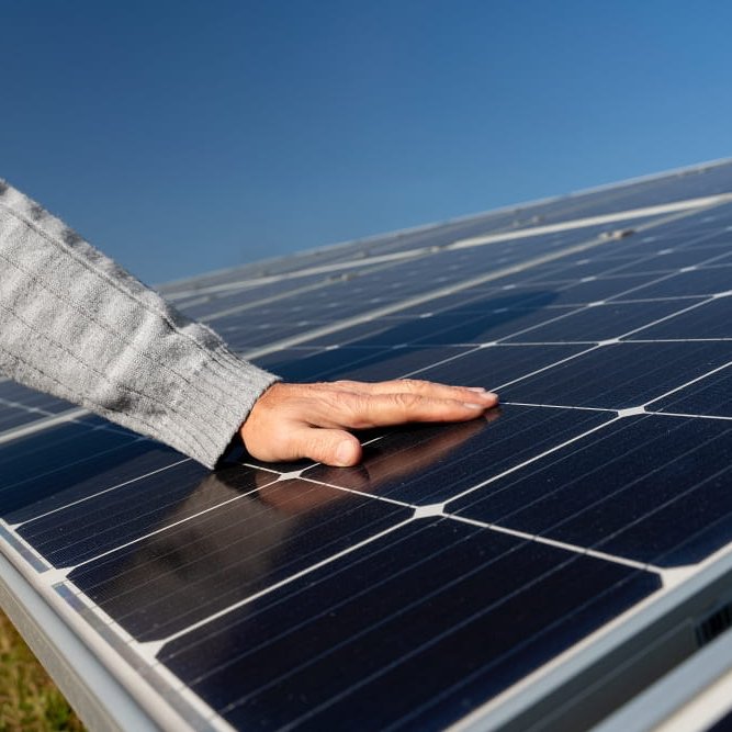 Hand auf Solarzelle