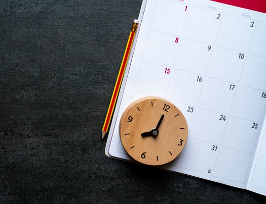 Hölzerne Uhr auf einem Kalender