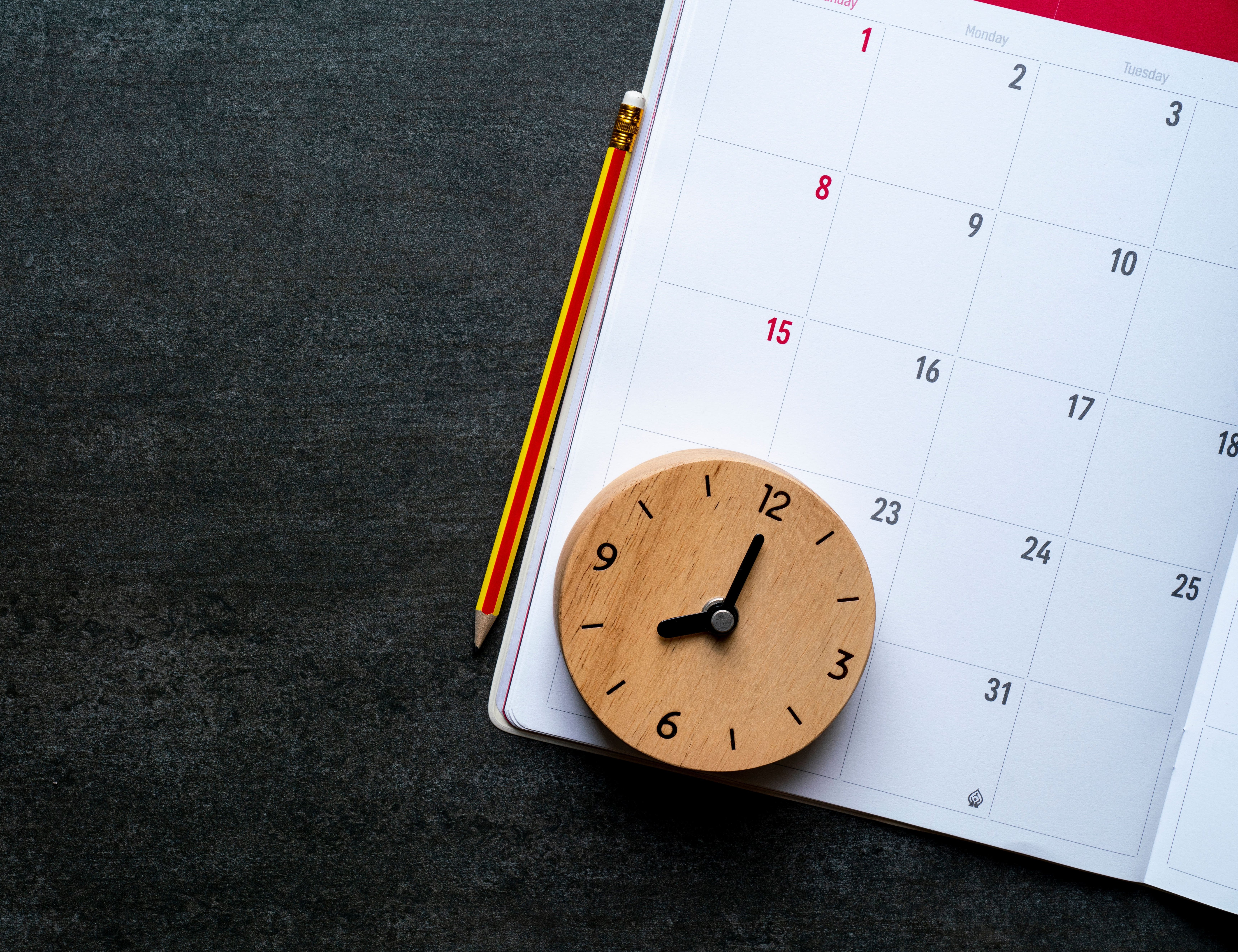 Hölzerne Uhr auf einem Kalender
