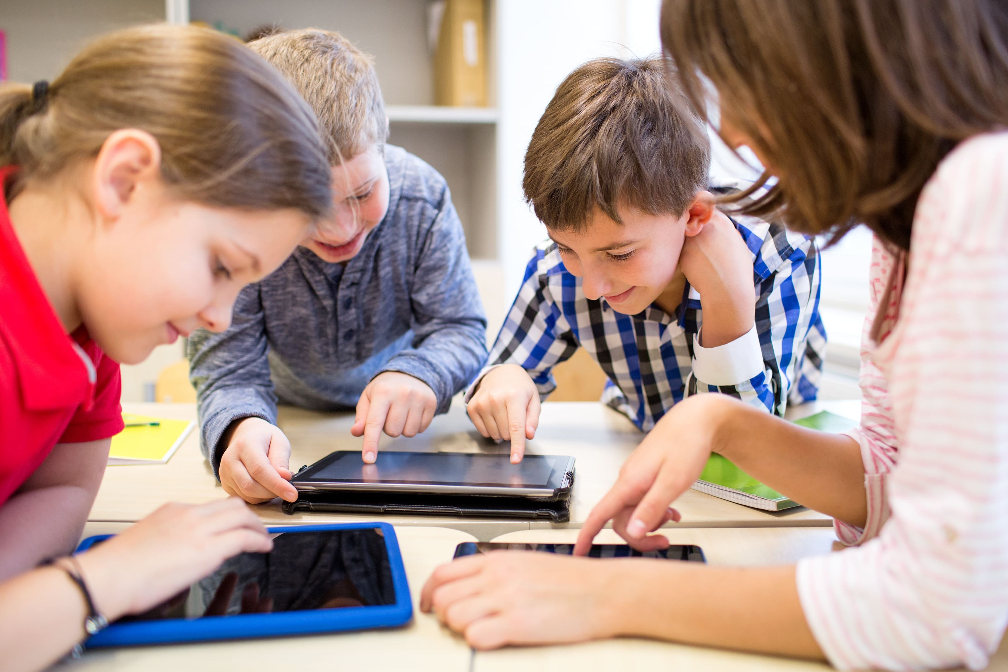 Schülerinnen und Schüler mit Smartphones und Tablets im Unterricht