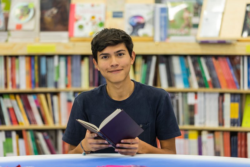 Schüler liest ein Buch in der Bibliothek 
