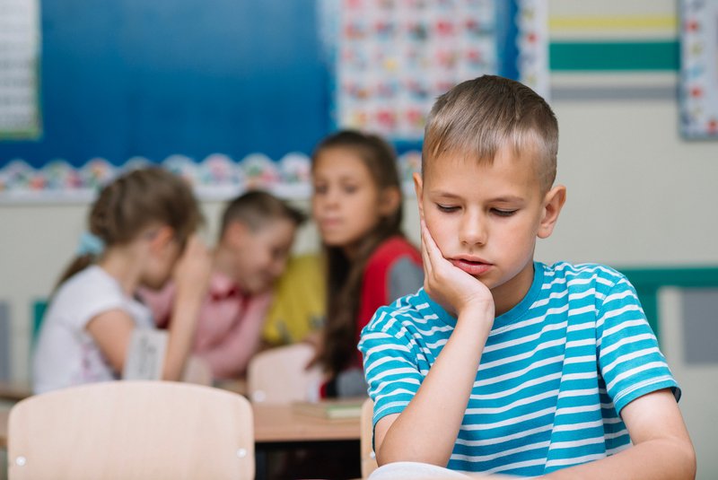 Schüler wird in Klasse geärgert und schaut traurig