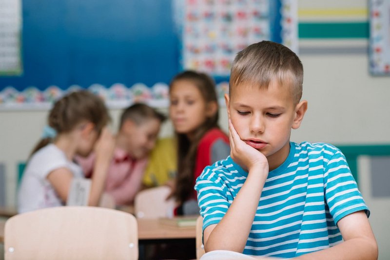 Schüler wird in Klasse geärgert und schaut traurig