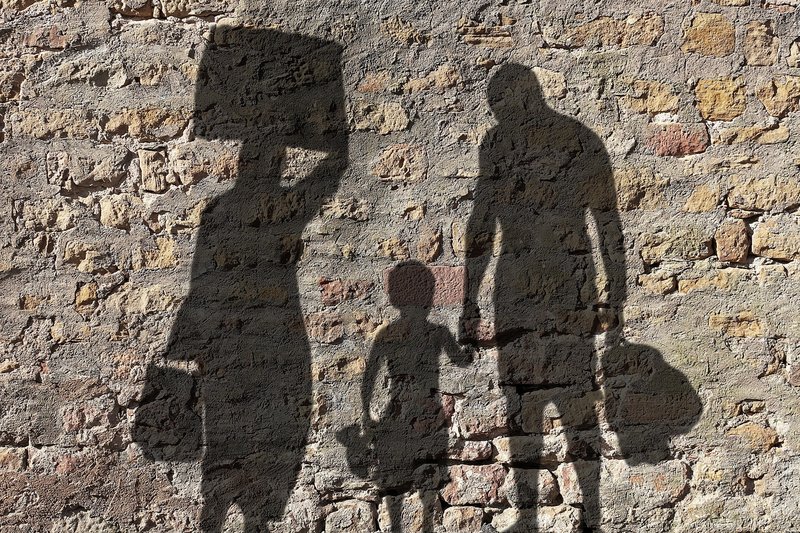Schatten von einer Familie mit Gepäck.