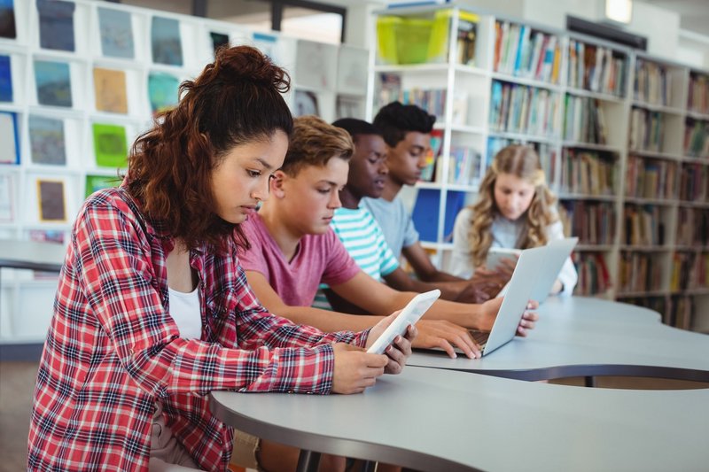 Lernende die Laptops und Tablets verwenden.