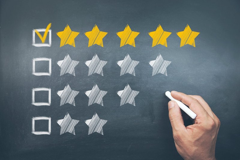 Hand mit Kreide die fünf Sterne abhackt.