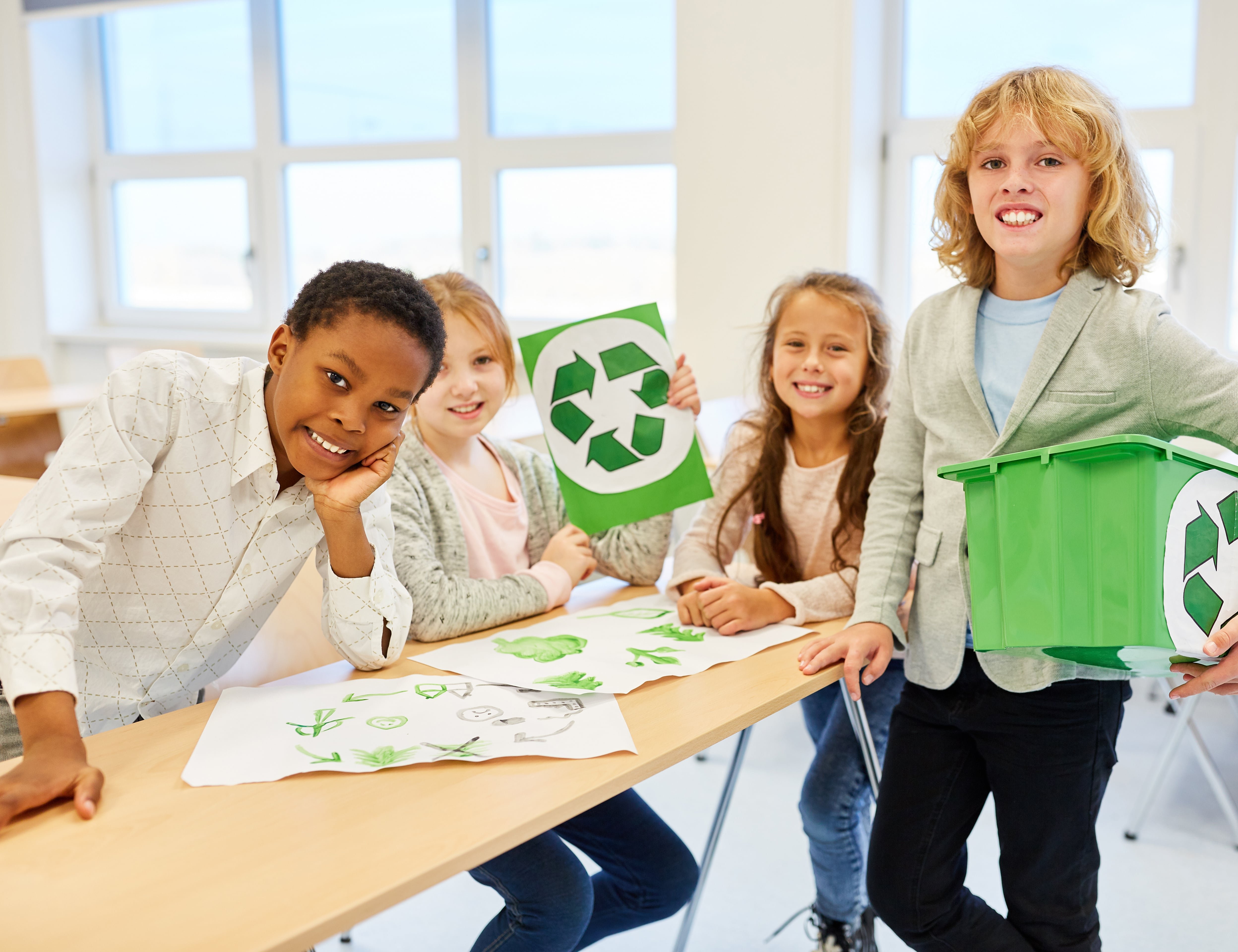 Schülerinnen und Schüler mit dem Recycling Zeichen 