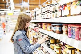 Ausbildung bei REWE Mädchen räumt Regale ein
