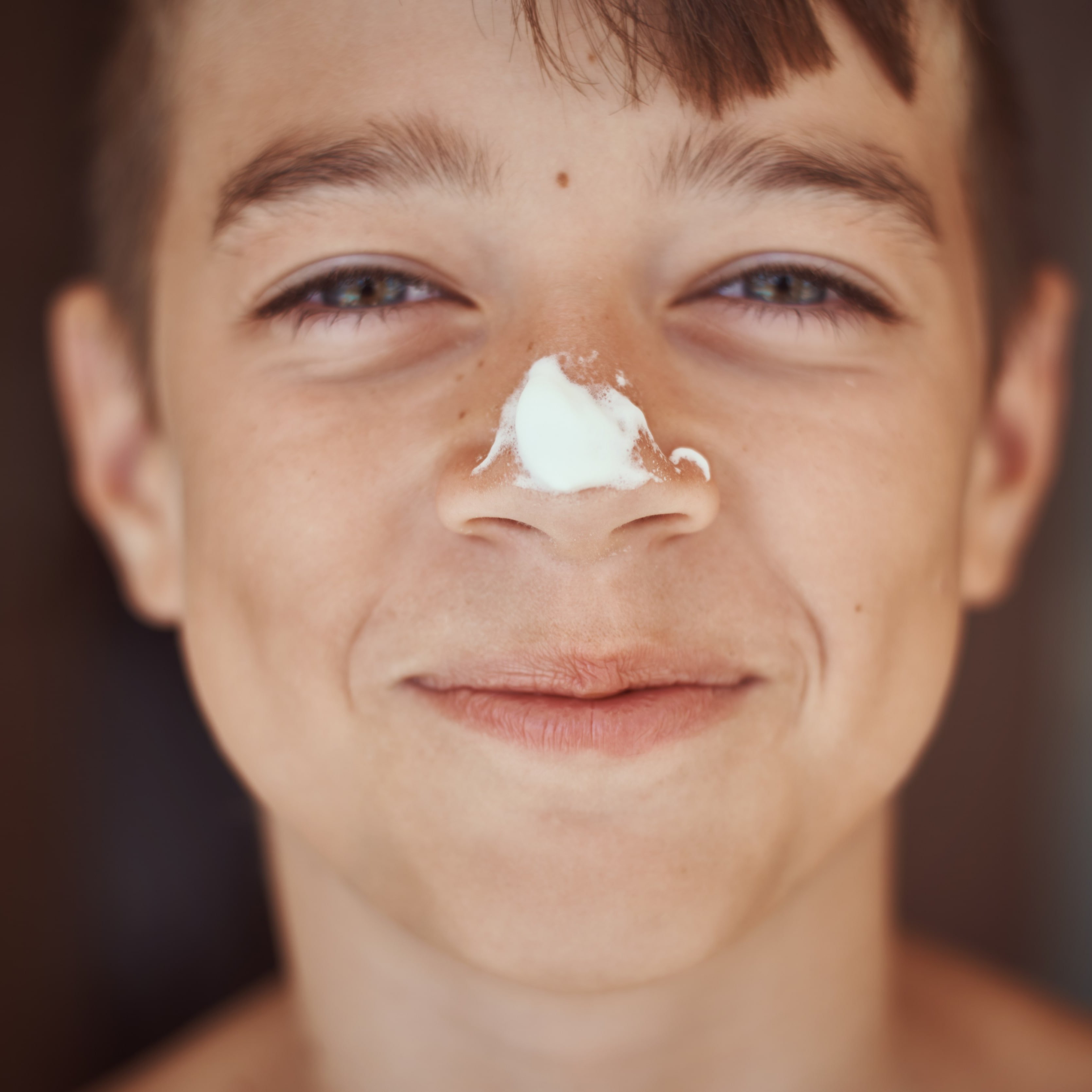 Unterrichtseinheit zum Thema Sonnenschutz Junge mit einen Kleks Sonnencreme auf der Nase