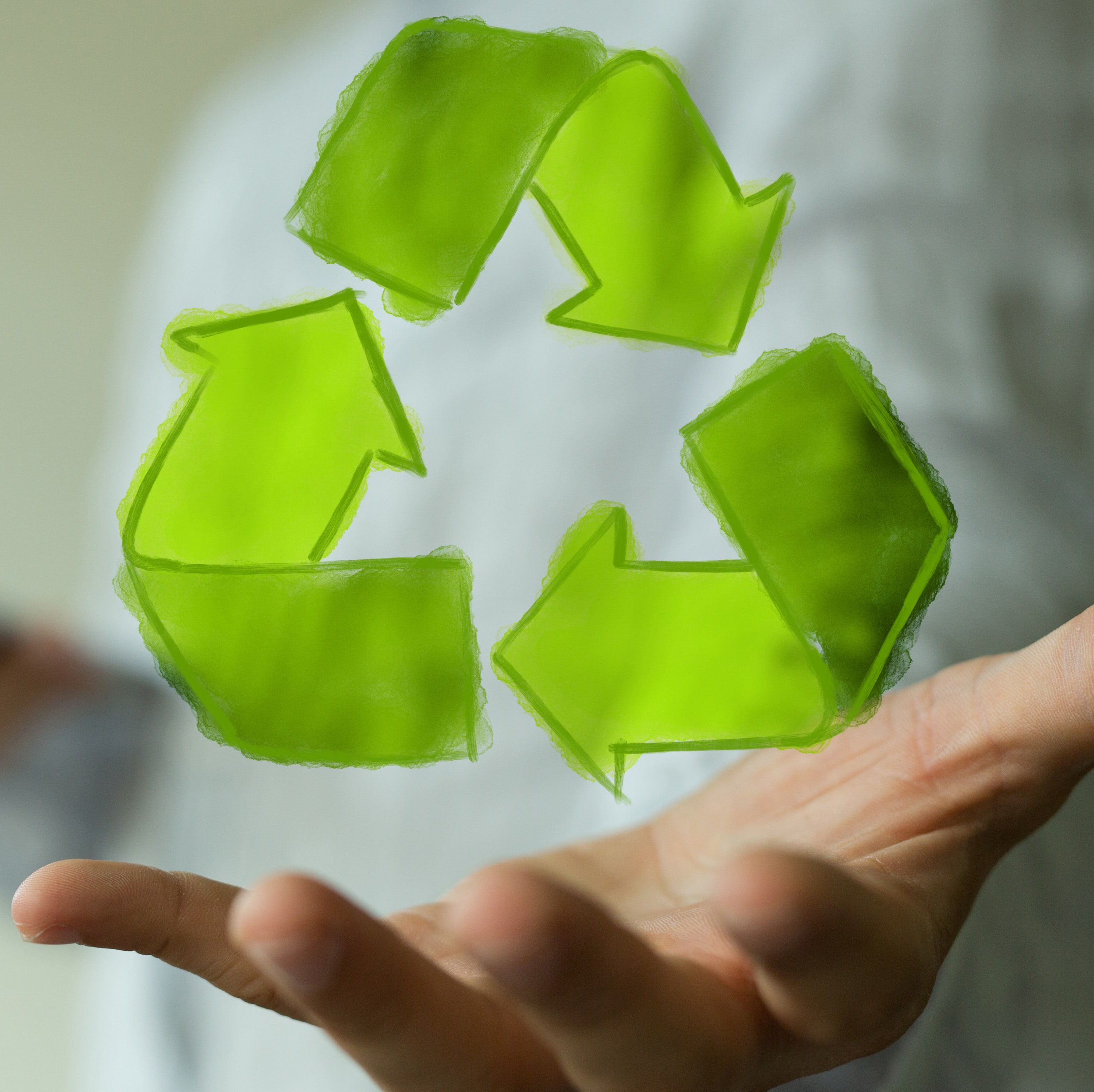 Kreislaufwirtschaft – Rezept gegen den Klimawandel? Hand über der das Reuse-Zeichen schwebt