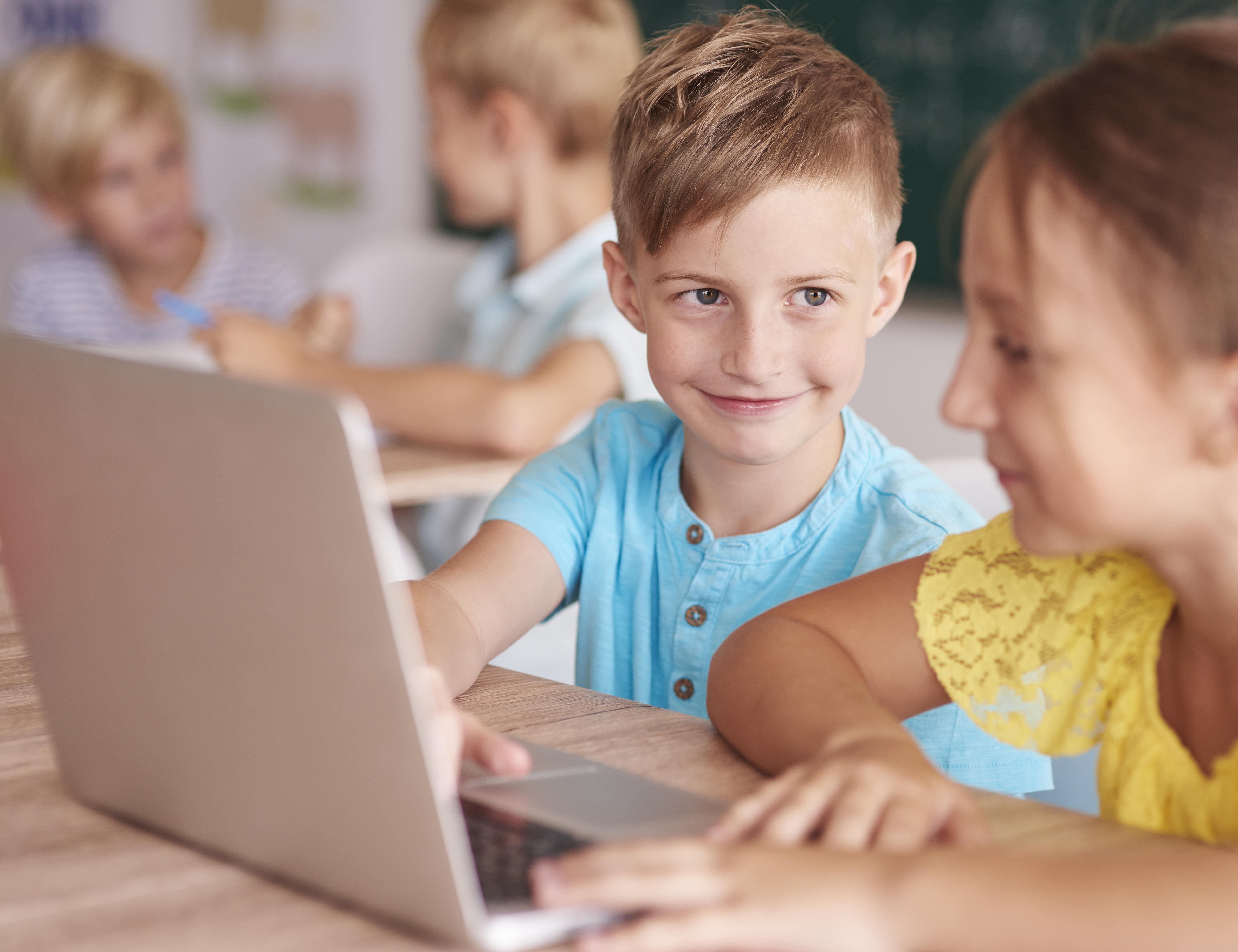 Junge und Mädchen schauen auf einen Computer
