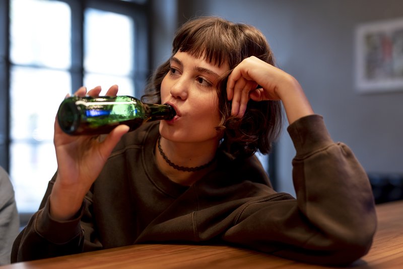 Schülerin trinkt ein Bier