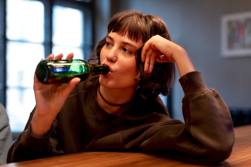 Schülerin trinkt ein Bier