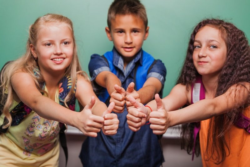 Kinder strecken Daumen hoch