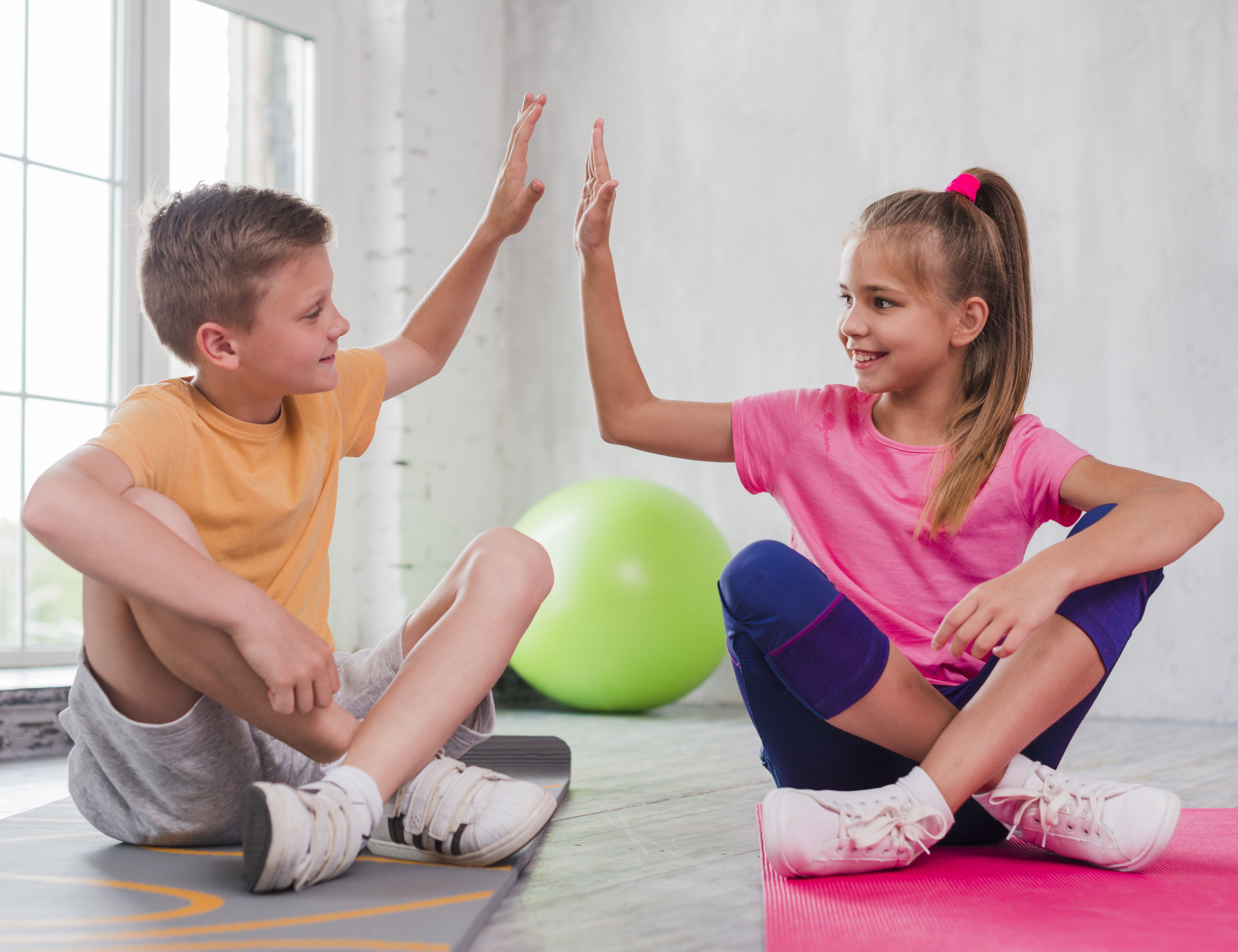 Kinder in Sportklamotten klatschen sich in die Hände