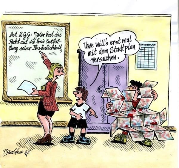 Stadtplan Lehrerin schreibt an Tafel, Schüler faltet Stadtplan auseinander