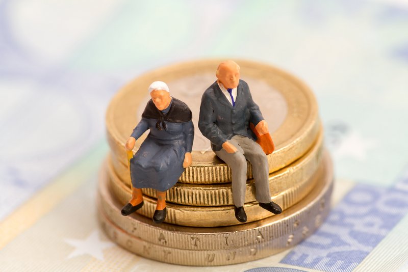 Figuren von alten Menschen sitzen auf Euro Münzen. 