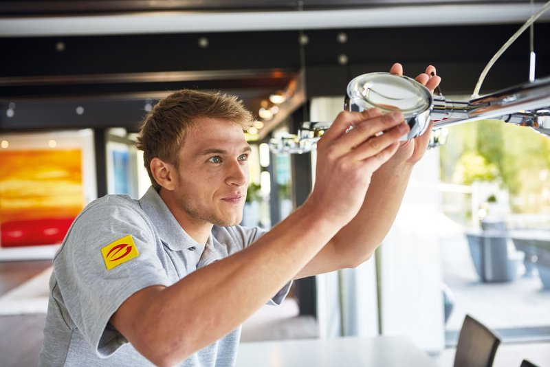 Handwerker installiert Leuchtmittel 