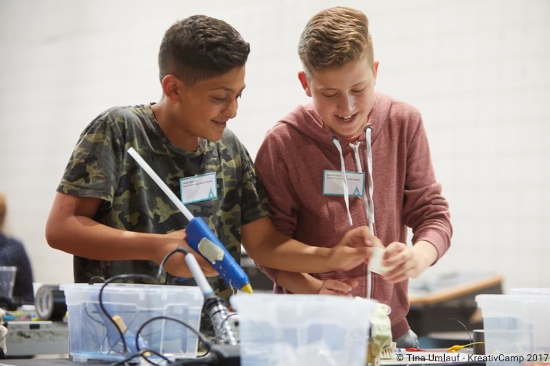 Zwei Jungen experimentieren mit Materialien im Kunstunterricht