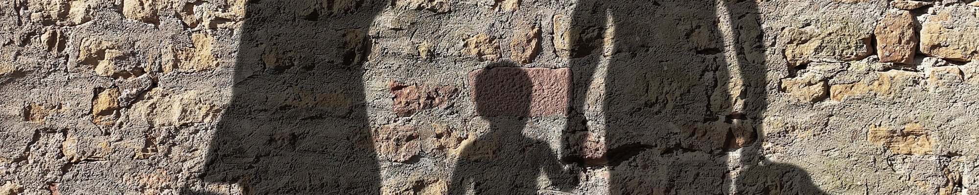 Schatten an einer Wand mit Koffern in der Hand.