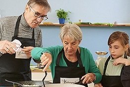Ein Mann, eine Frau, ein Kind beim Kochen