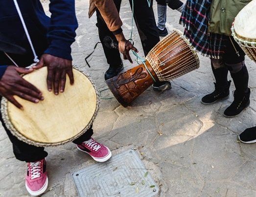 Menschen spielen auf afrikanischen Trommeln
