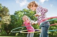 Kinder spielen mit Hulla-Hupp Reifen