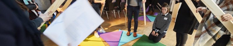 Gruppe Menschen versucht sich mit Realia an der Multiplikation von Brüchen