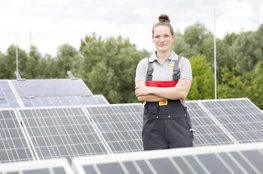 Aktuelle Unterrichtseinheit "Erneuerbare Energien im Detail" für Sekundarstufe II Frau steht vor Solarpanelen