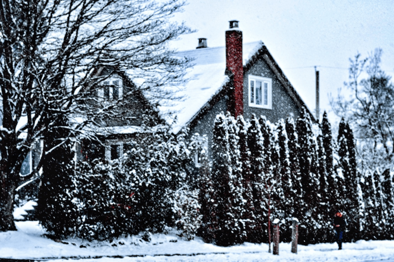 Ein mit Schnee bedecktes Haus in einer ländlichen Umgebung.