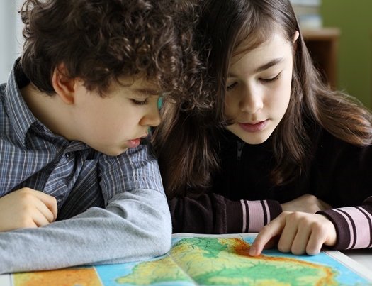 Kinder arbeiten mit dem Atlas
