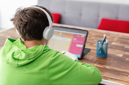Let’s get digital: Lernmaterialien zum digitalen Lernen auf „Energie macht Schule“ Junge mit Kopfhörer vor Tablet