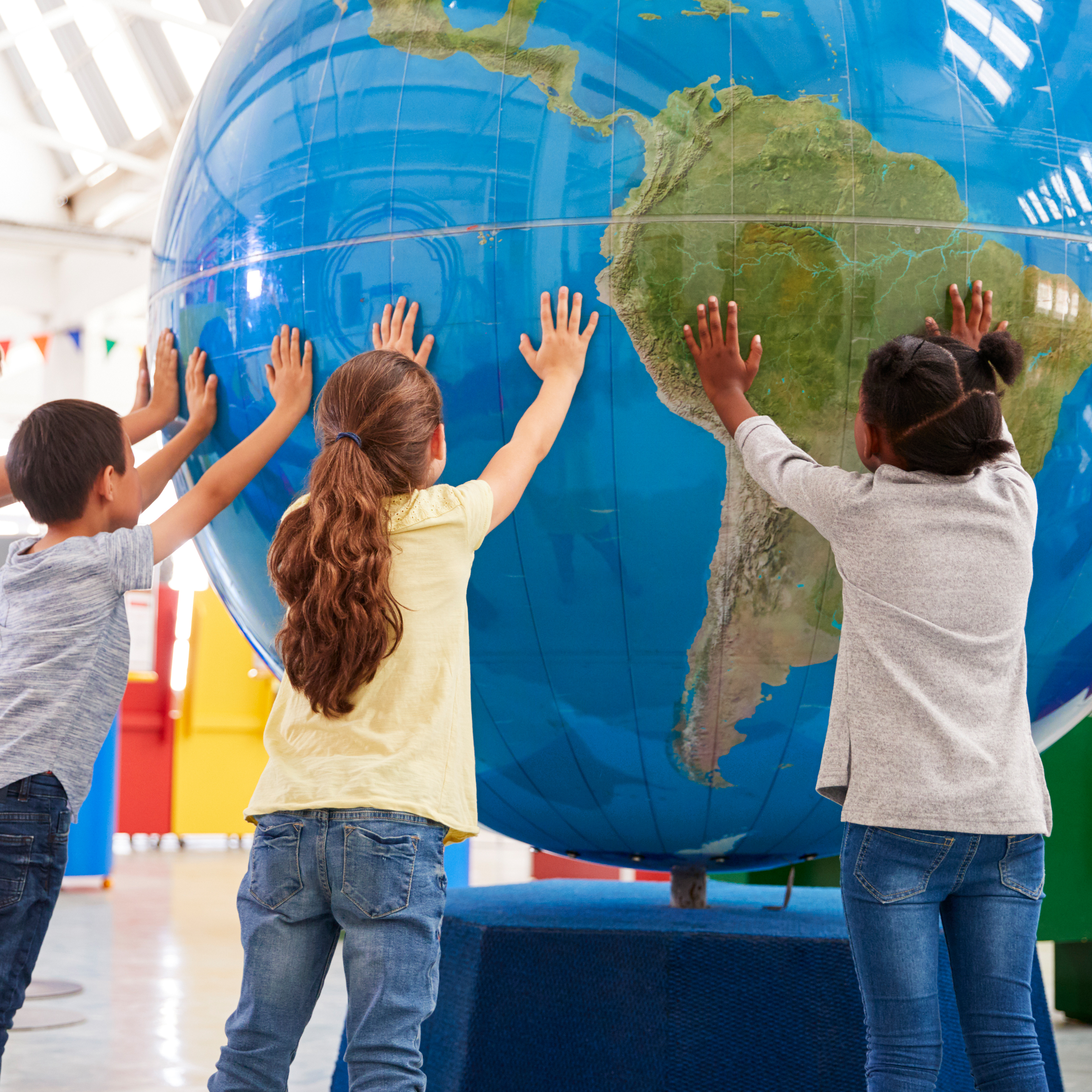 Kinder stützen einen großen Globus