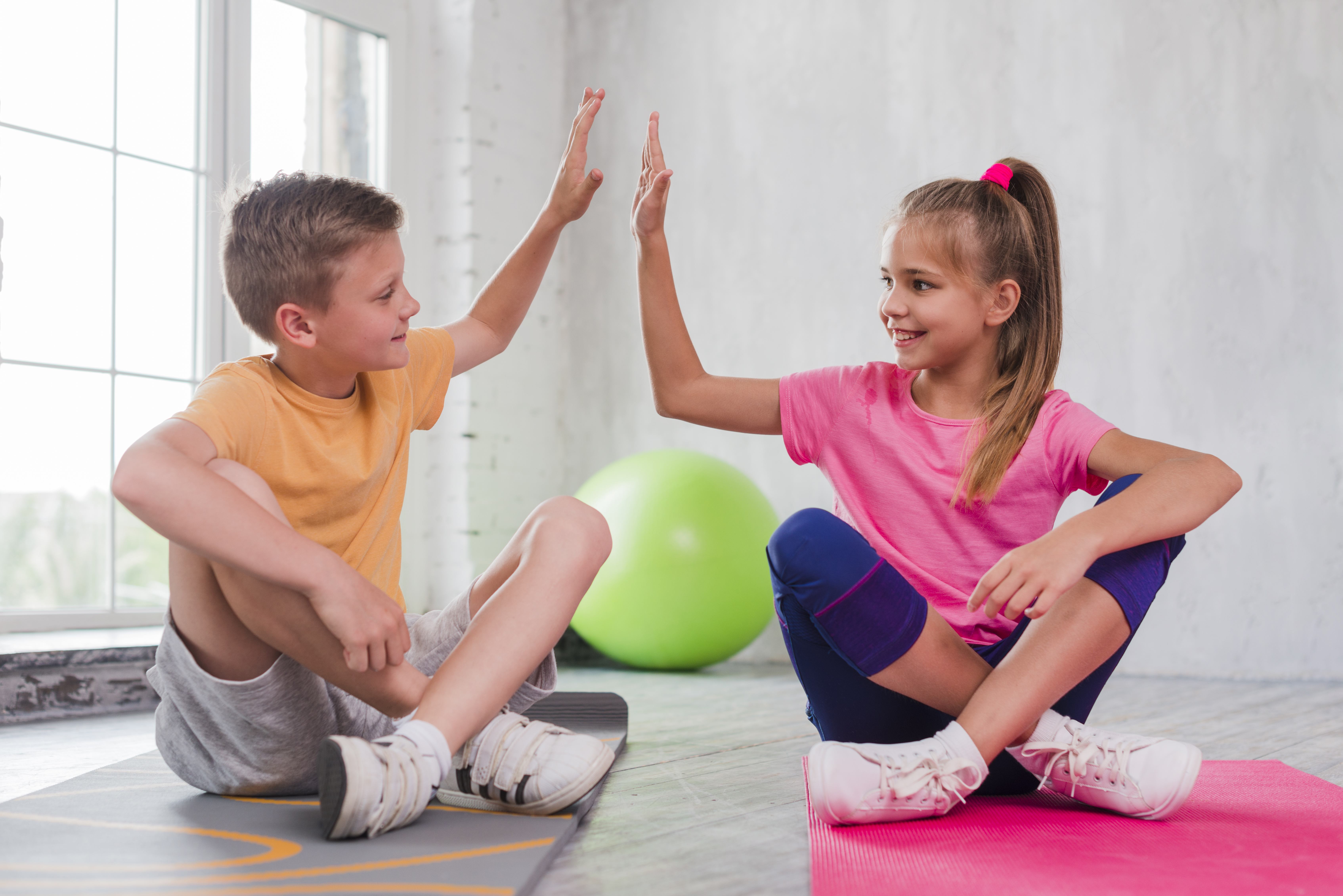 Kinder in Sportklamotten klatschen sich in die Hände
