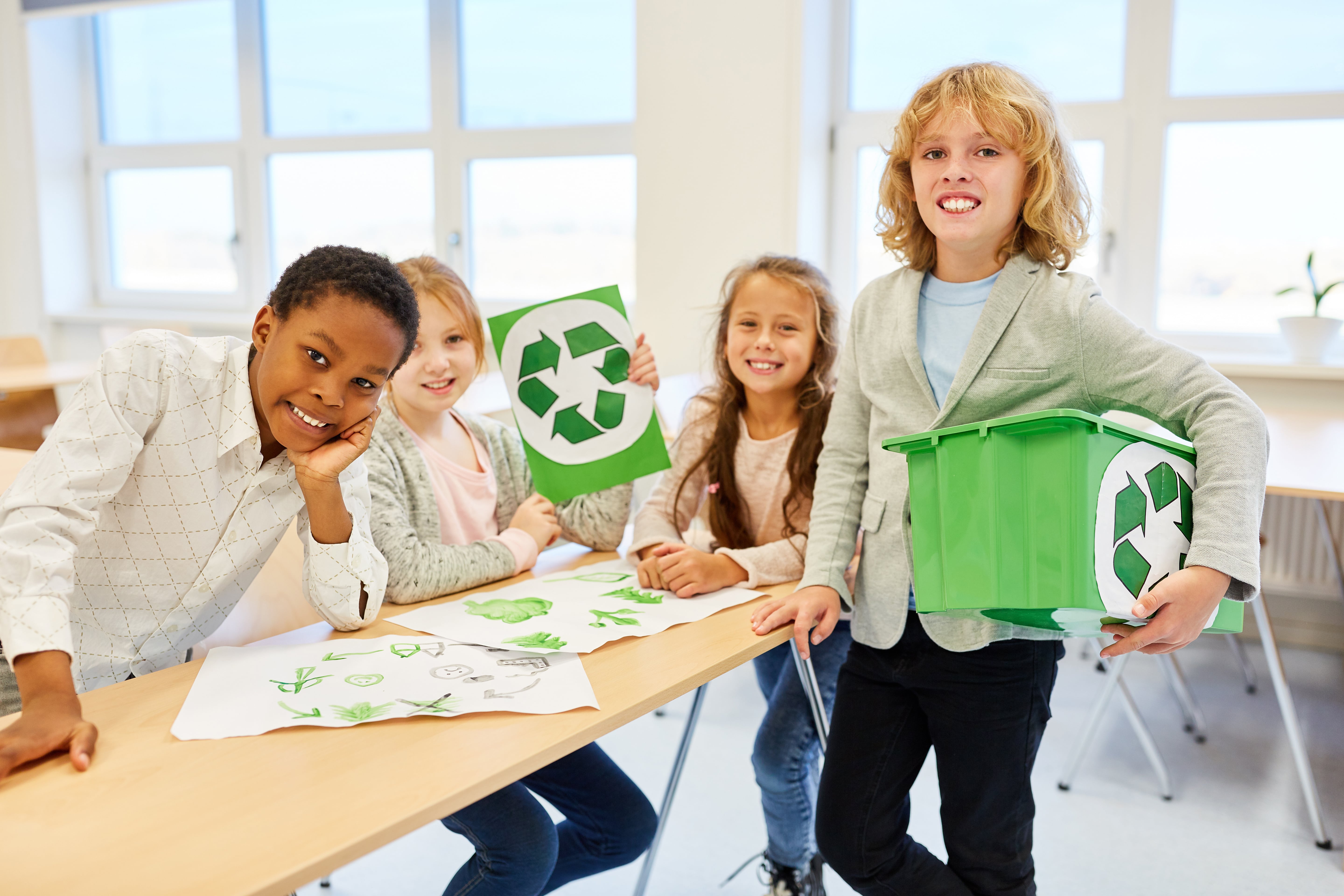 Schülerinnen und Schüler mit dem Recycling Zeichen 