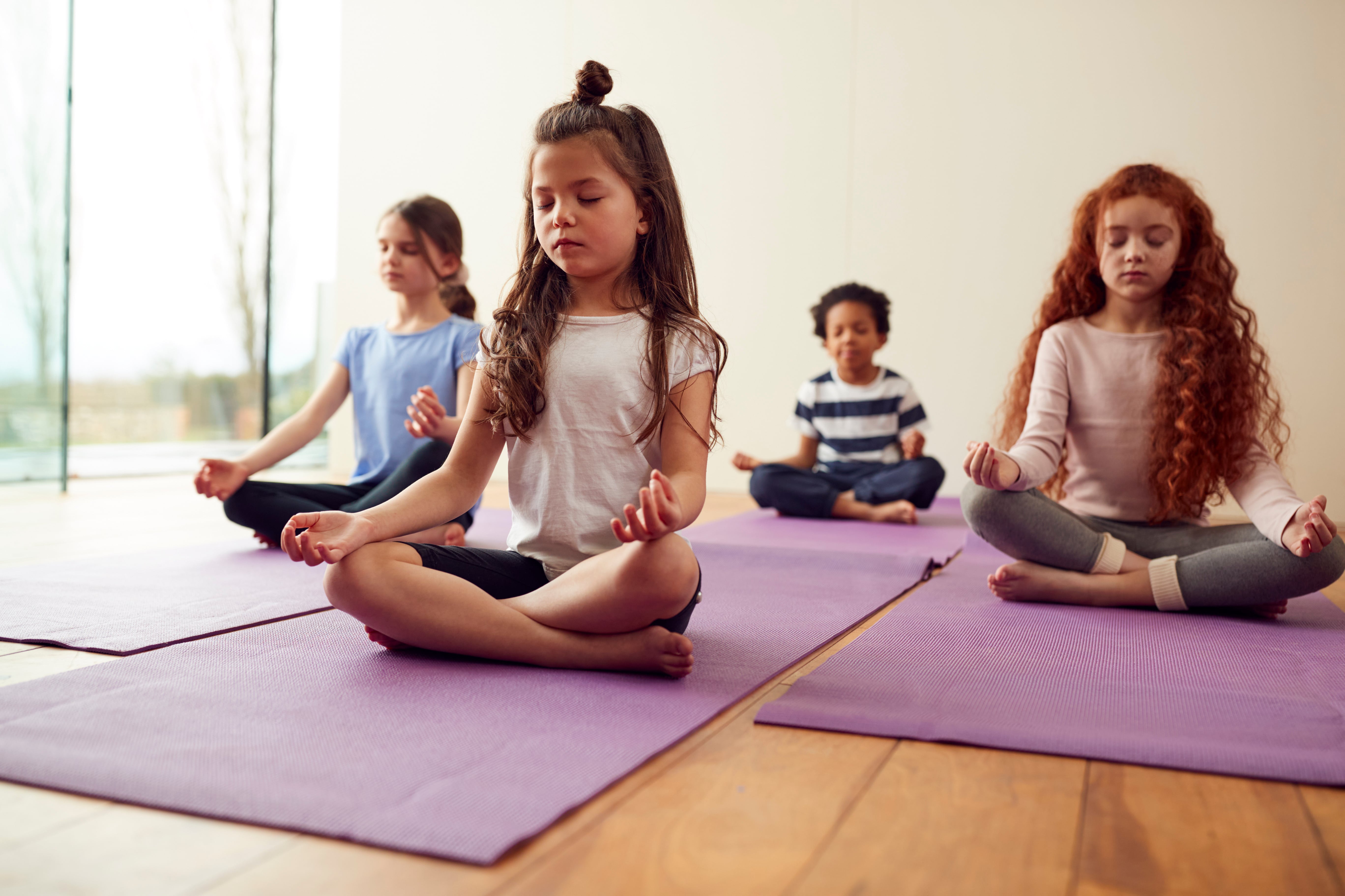 Schülerinnen und Schüler machen Yoga