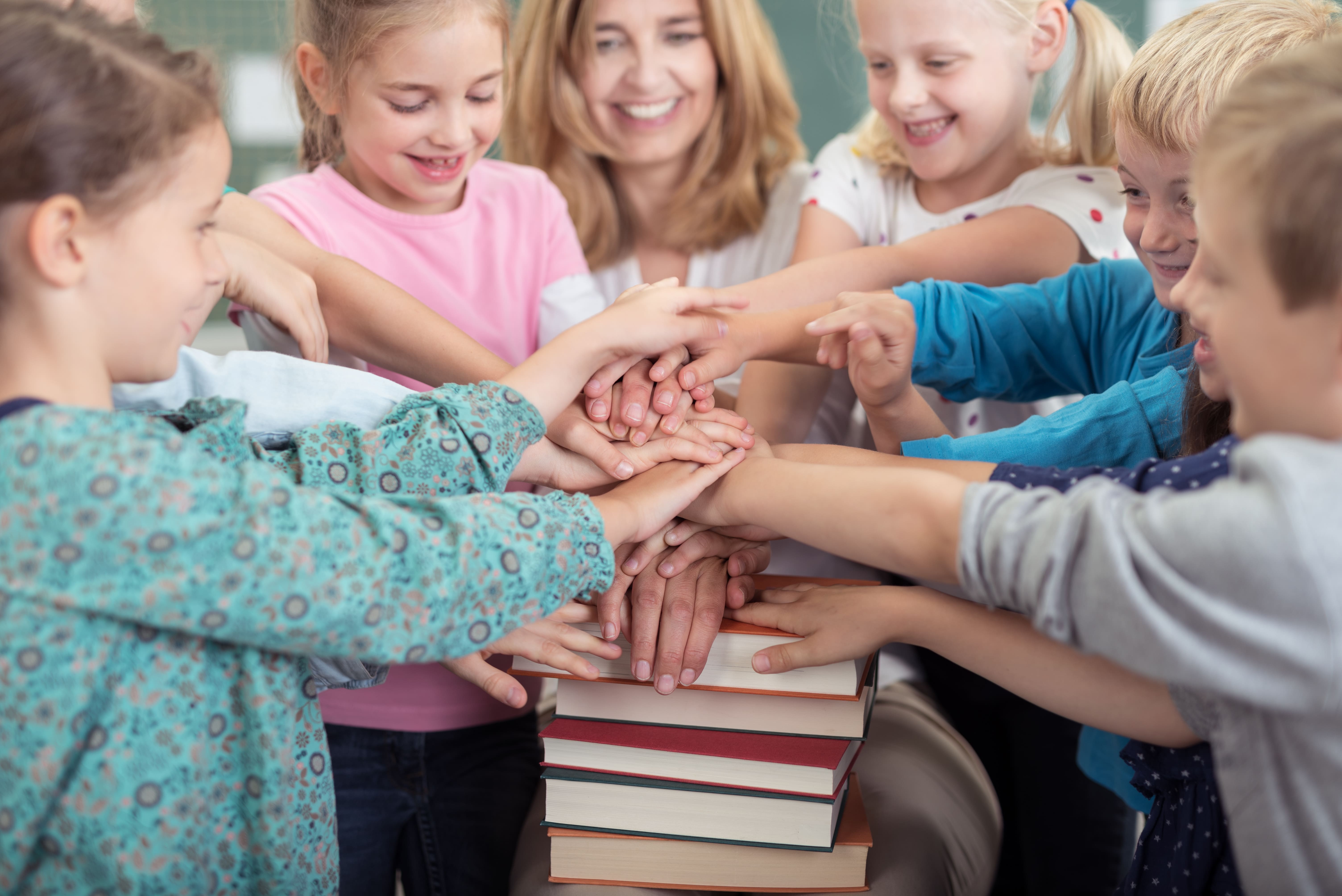 Kinder stapeln Hände aufeinander