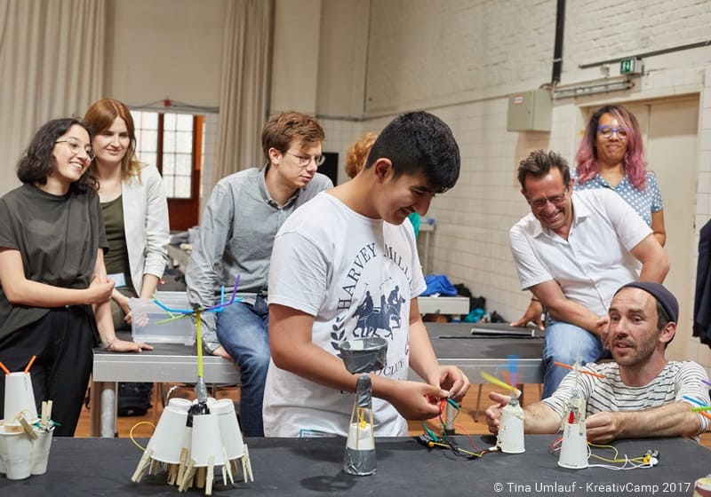 Kunstschaffende und Schüler am gemeinsamen Projekt